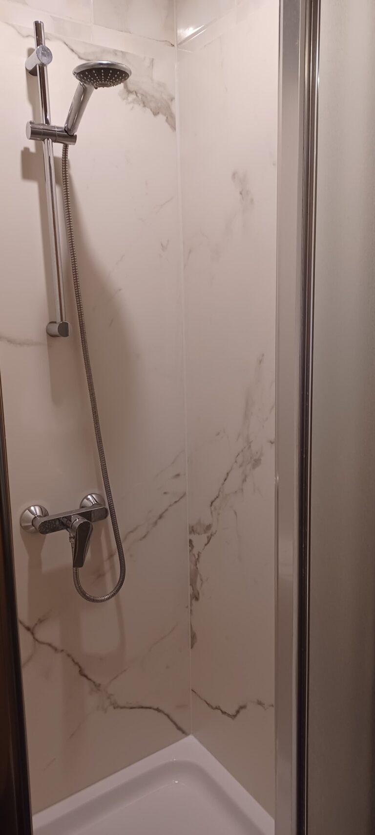 eine neu verkleidete Duschkabine mit Keramikplatte