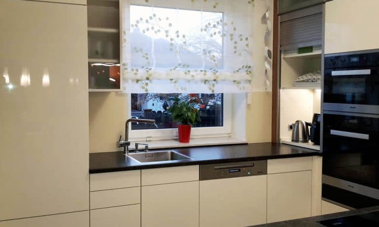 Weiße Küche hochglanz mit schwarzer Arbeitsplatte von Voak Andreas